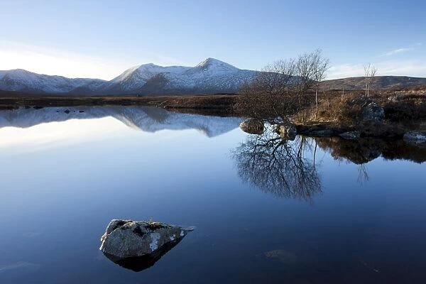 Dusk view of snow-covered Black Mount Hills and their reflection in the flat calm Lochain na h Achlaise, Rannoch Moor, Highland, Scotland, United
