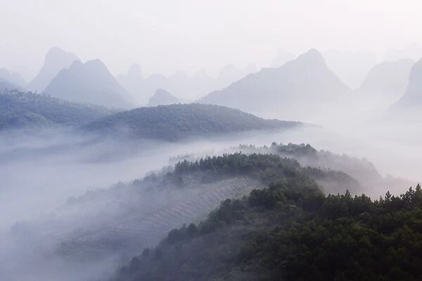 Early morning mist clinging to karst limestone scenery around Yangshuo
