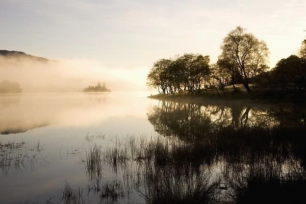 Early morning mist reflected in the still waters of Loch Achray, near Aberfoyle