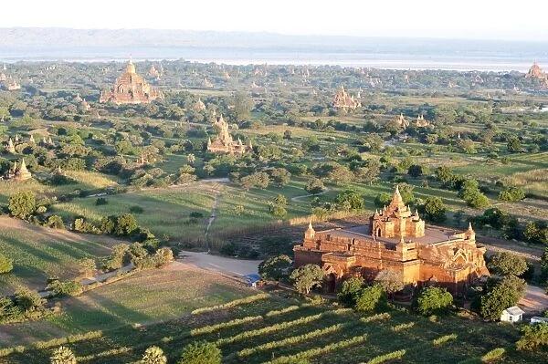 Early morning sunshine over the terracotta temples of Bagan, the Irrawaddy river in the distance