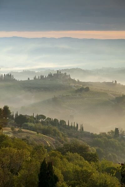 Early morning view across misty hills from San Gimignano, Tuscany, Italy, Europe