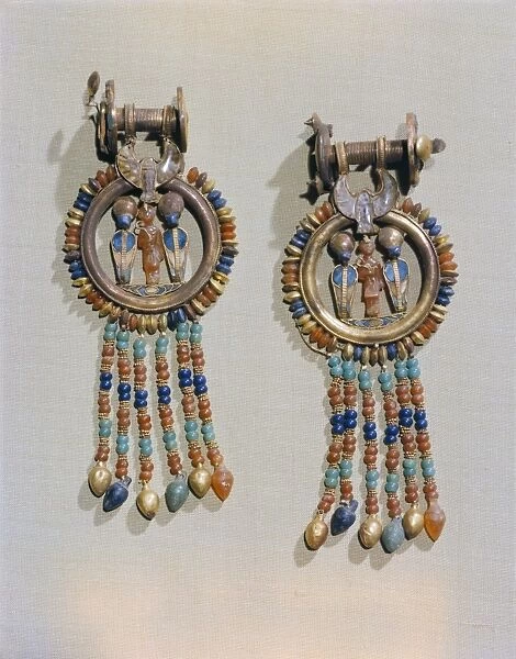 Earrings which show the king flanked by two sacred serpents in the centre of the clip