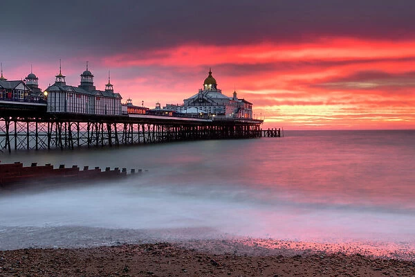 Eastbourne Pier against fiery red sky at sunrise, Eastbourne, East Sussex, England