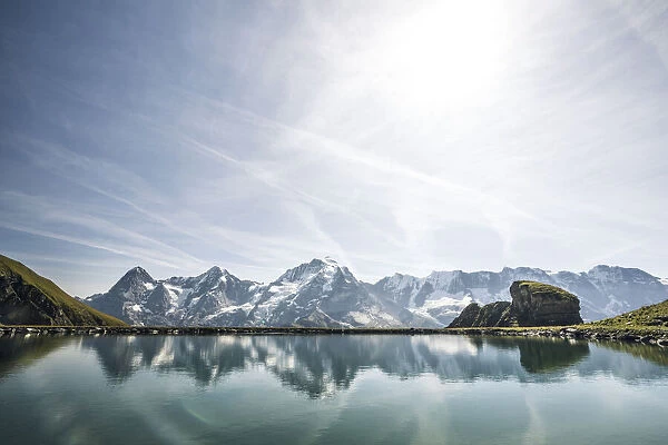 Eiger, Monch and Jungfrau peaks reflected in the unspoiled Engital lake, Murren Birg