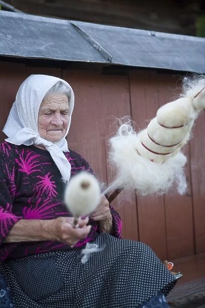 Elderly woman spinning wool, Budesti, Maramures, Romania, Europe