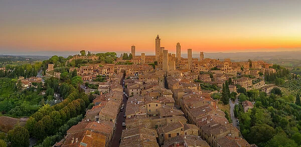 Elevated view of rooftops and town at sunrise, San Gimignano, Tuscany, Italy, Europe
