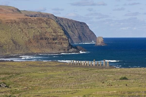 Elevated view of a row of monolithic stone Moai statues at Tongariki and the rugged coastline of Rapa Nui (Easter Island), UNESCO World Heritage Site, Chile