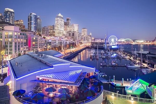 Elevated view of Seattle skyline and restaurants in Bell Harbour Marina at dusk, Belltown District