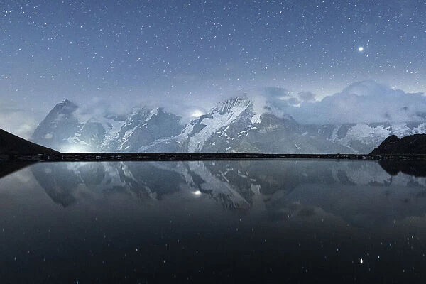 Engital lake under the starry sky with Eiger, Monch and Jungfrau mountains in