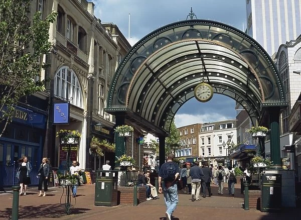 Entrance to shopping arcade with clock on a pedestrianised street off The Square