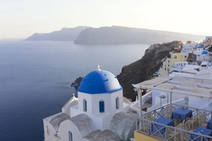 Framed Print : Evening view over the Caldera from Oia with blue domed church and distant volcanic cliffs Framed Print : Evening view over the Caldera from Oia with blue domed church and distant volcanic cliffs