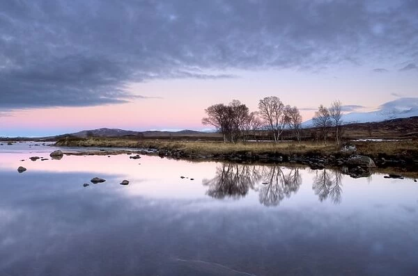 Evening view over flat calm Loch Ba with pink afterglow in sky, reflected in loch