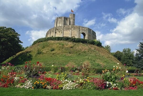 Exterior of 11th century castle on mound at Gisors with flower border below