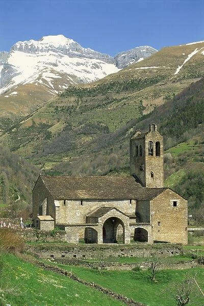Exterior of church in a valley with mountains in the