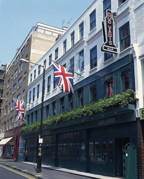 Exterior of Quo Vadis bar and restaurant, Union flags flying, Soho, London
