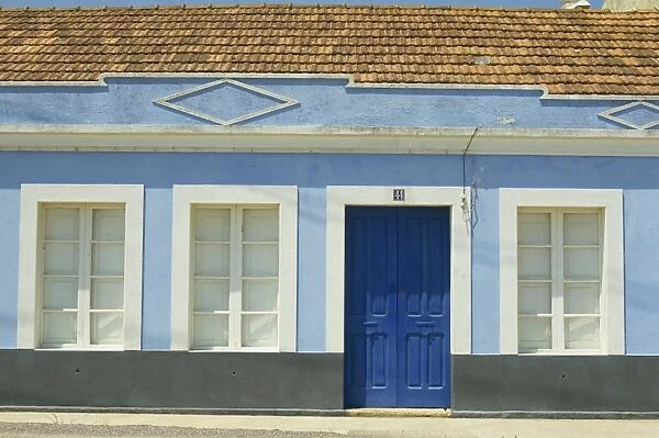 Exterior of a single storey house with blue walls and door