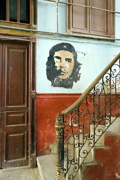 Faded mural of Che Guevara on the staircase of a dilapidated apartment building