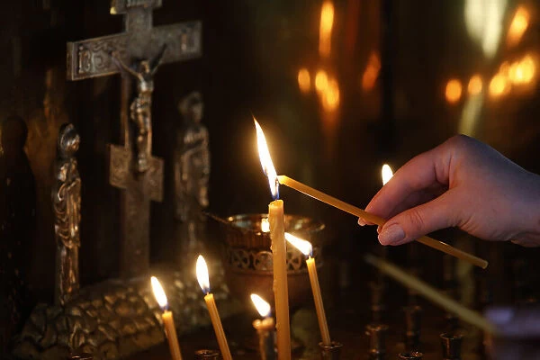 Faithful lighting a candle in Saint Teaodor Tiron (Ciuflea) Cathedral and Monastery