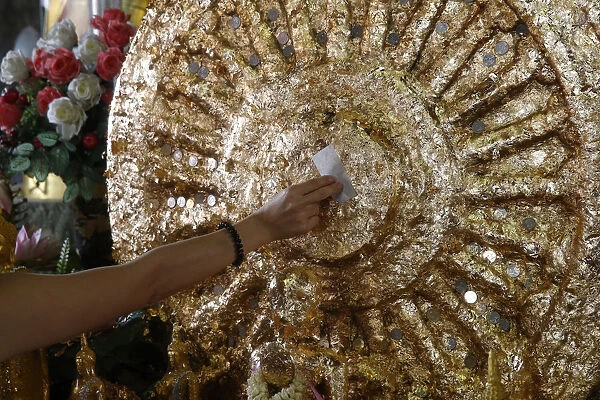 Faithful offering gold leaves in Wat Mahathat, Phetchaburi, Thailand, Southeast Asia
