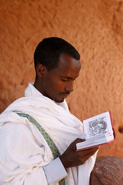 Faithful reading outside a church in Lalibela, Ethiopia, Africa