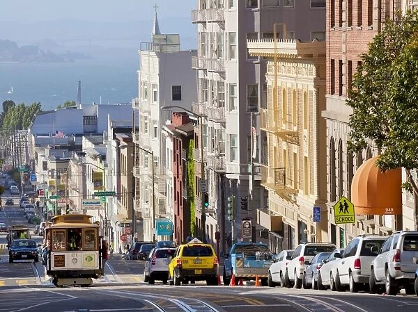 One of the famous cable cars on the Powell-Mason track, with the island of Alcatraz in the background, San Francisco, California, United States of America