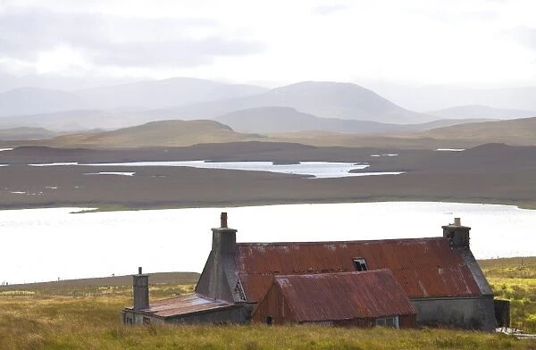 Farmhouse with red iron roof overlooking lochs and mountains off the A858 south of Carloway, Isle of Lewis, Outer Hebrides, Scotland, United Kingdom, Europe