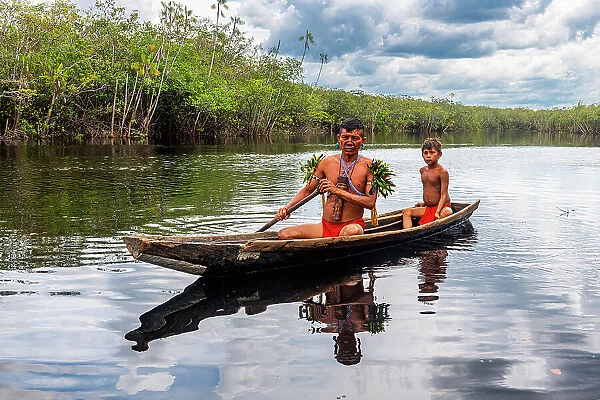 Father and son from the Yanomami tribe in a canoe, southern Venezuela, South America