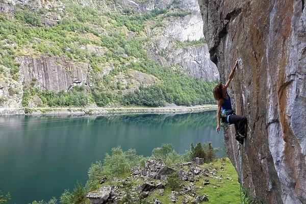 A female climber tackles a steep cliff at Loven, near Aurland, western Norway, Scandinavia, Europe