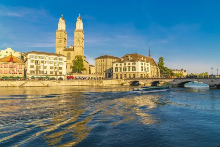 Framed Print : Ferry along Limmat River next to Munsterbrucke bridge with Grossmunster in background Framed Print : Ferry along Limmat River next to Munsterbrucke bridge with Grossmunster in background