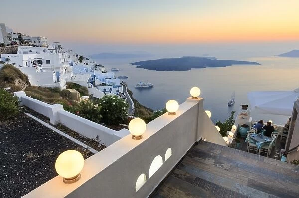 The fiery red sky on the Aegean Sea after sunset seen from the typical terraces of Firostefani