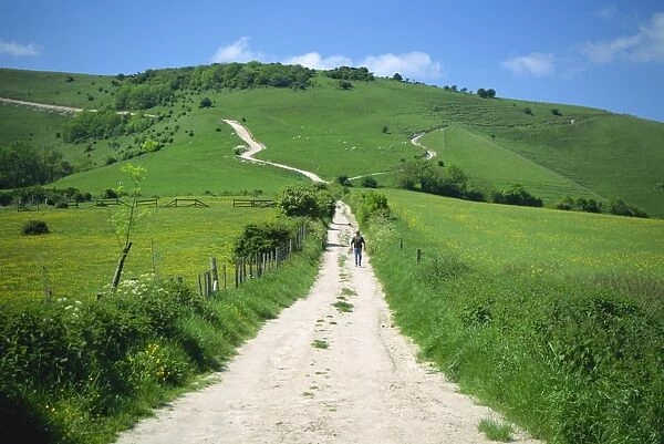 Figure on a pathway leading up a hill in the South Downs, near Lewes, Sussex