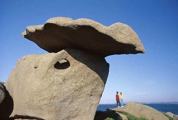 Two figures below precarious granite rocks, Ploumanach, Cotes d Armor