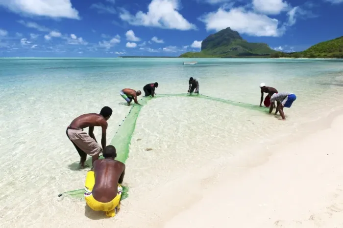 Framed Print : Fisherman on a beach being overlooked by the basaltic monolith, Le Morne, Black River