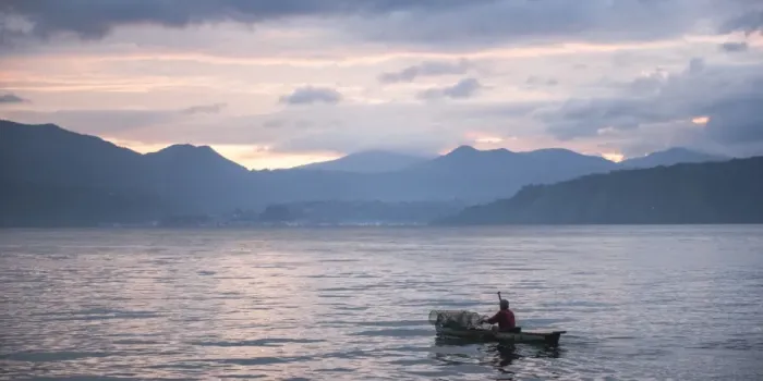 Framed Print : Fisherman in a fishing boat on Lake Toba (Danau Toba) at sunrise, North Sumatra, Indonesia