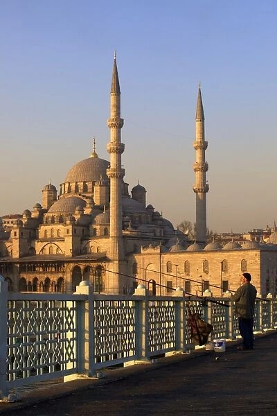 Fisherman on Galata Bridge with New Mosque in background, Istanbul, Turkey, Europe