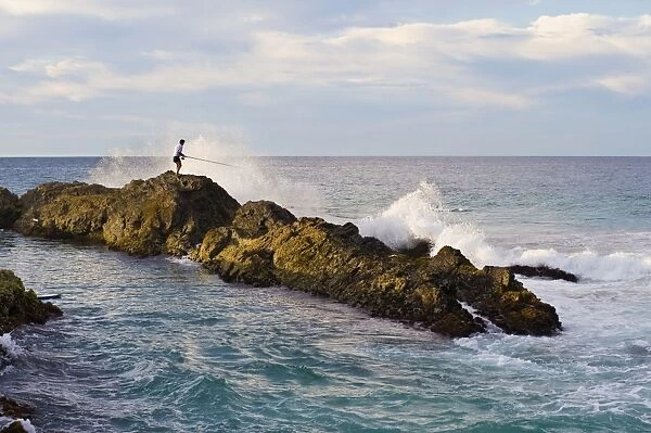 Fisherman getting hit by a wave while rock fishing at Snapper Rocks, Tweed Heads, Gold Coast, Queensland, Australia, Pacific