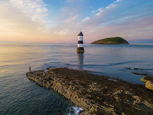 Fisherman at Trwyn Du Lighthouse at sunset in summer, Beaumaris, Wales, Great Britain, United Kingdom, Europe