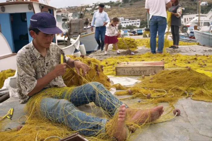 Framed Print : Fisherman using hands and feet to repair fishing net on Mykonos Framed Print : Fisherman using hands and feet to repair fishing net on Mykonos
