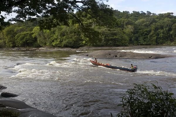 Fishermen going against the rapids on the Approuague River, French Guiana, South America