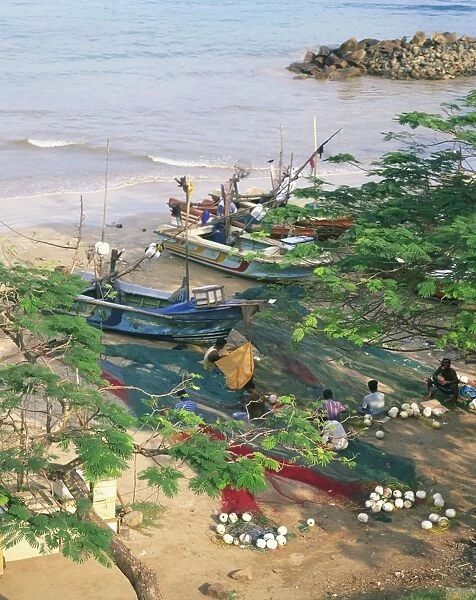 Fishermen mending their nets in the fishing harbour at Galle