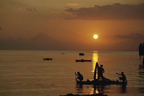 Fishermen silhouetted at sunset at Ende on the island of Flores