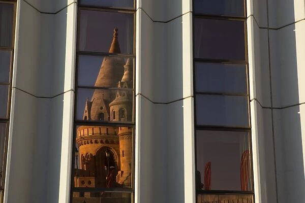 Fishermens Bastion (Halaszbastya) reflected in windows of Hilton Hotel, Buda, Budapest, Hungary, Europe