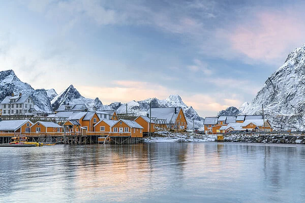 Fishermens wood cabins covered with snow at sunset in the tiny village of Sakrisoy, Reine, Nordland, Lofoten Islands, Norway, Scandinavia, Europe