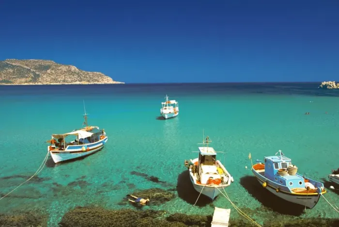Framed Print : Fishiing boats and man snorkelling at Anopi Beach, Karpathos, Dodecanese