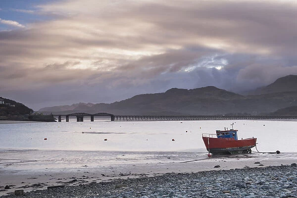 Fishing boat and Barmouth Bridge in Barmouth Harbour with Cader (Cadair) Mountains behind