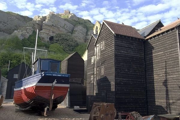 Fishing boat and historic buildings with Hastings Castle in the background