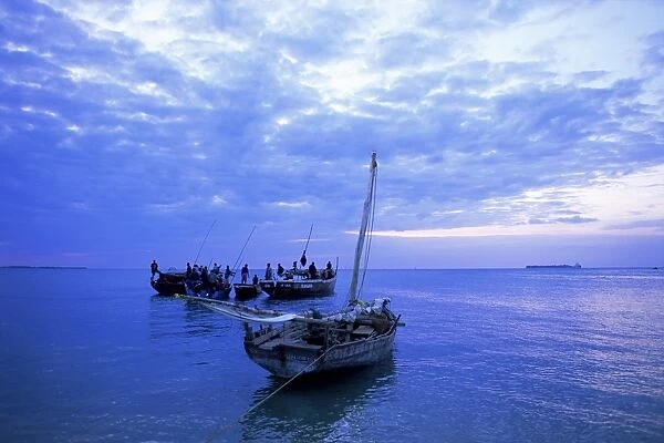 Fishing boats on the Indian Ocean at dusk, off Stone Town, Zanzibar, Tanzania