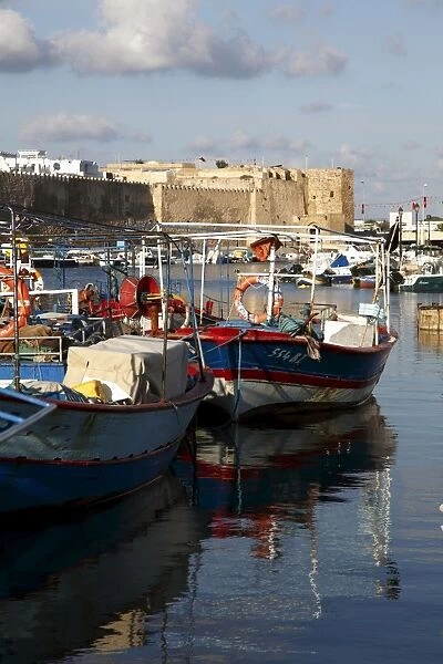 Fishing boats, old port canal with kasbah wall in background, Bizerte, Tunisia