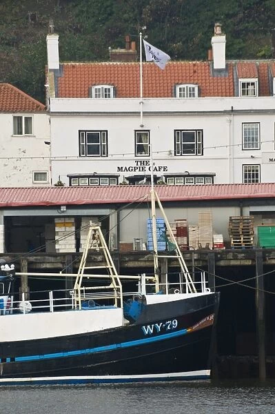 Fishing boats in Whitby harbour with the famous Magpie Cafe in the background