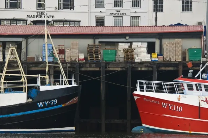 Framed Print : Fishing boats in Whitby harbour with the famous Magpie Cafe in the background Framed Print : Fishing boats in Whitby harbour with the famous Magpie Cafe in the background